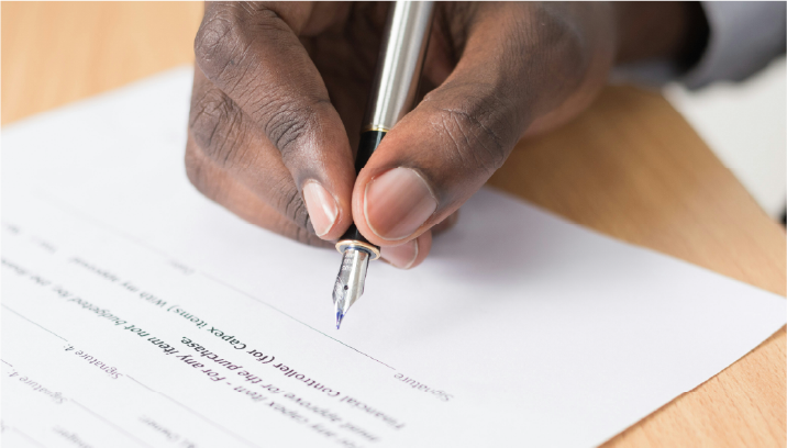 photo of a hand signing a contract